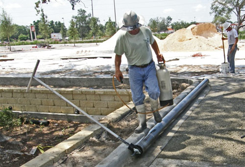Release Agent being applied to roller to prevent pervious raveling