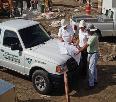 Charlie, Carolyn and Concrete Operations Vice President, Gerald Mims review plans at construction site.